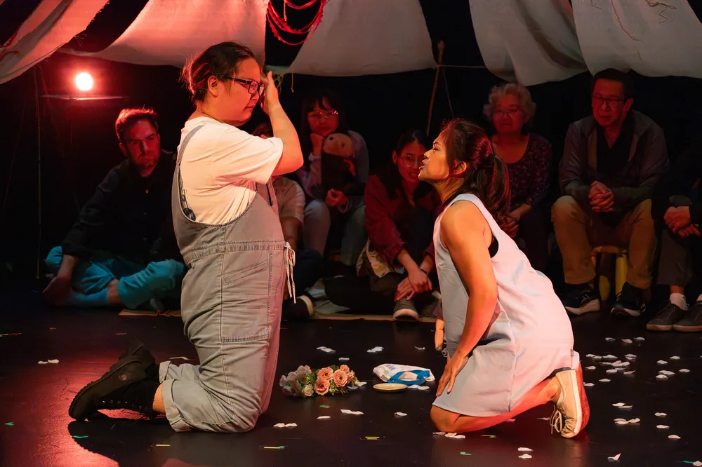 A man and a woman sitting on a stage