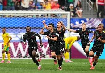 Eustáquio runs up the pitch with his teammates, celebrating his game-winning goal.