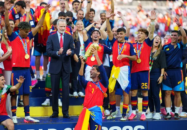 Ferran Torres hoists the World Cup trophy with his team on stage after defeating Argentina.