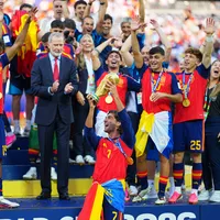 Ferran Torres hoists the World Cup trophy with his team on stage after defeating Argentina.
