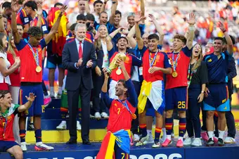 Ferran Torres hoists the World Cup trophy with his team on stage after defeating Argentina.