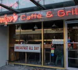The front door of Evelyn's Cafe and Bistro with a neon sign above it.