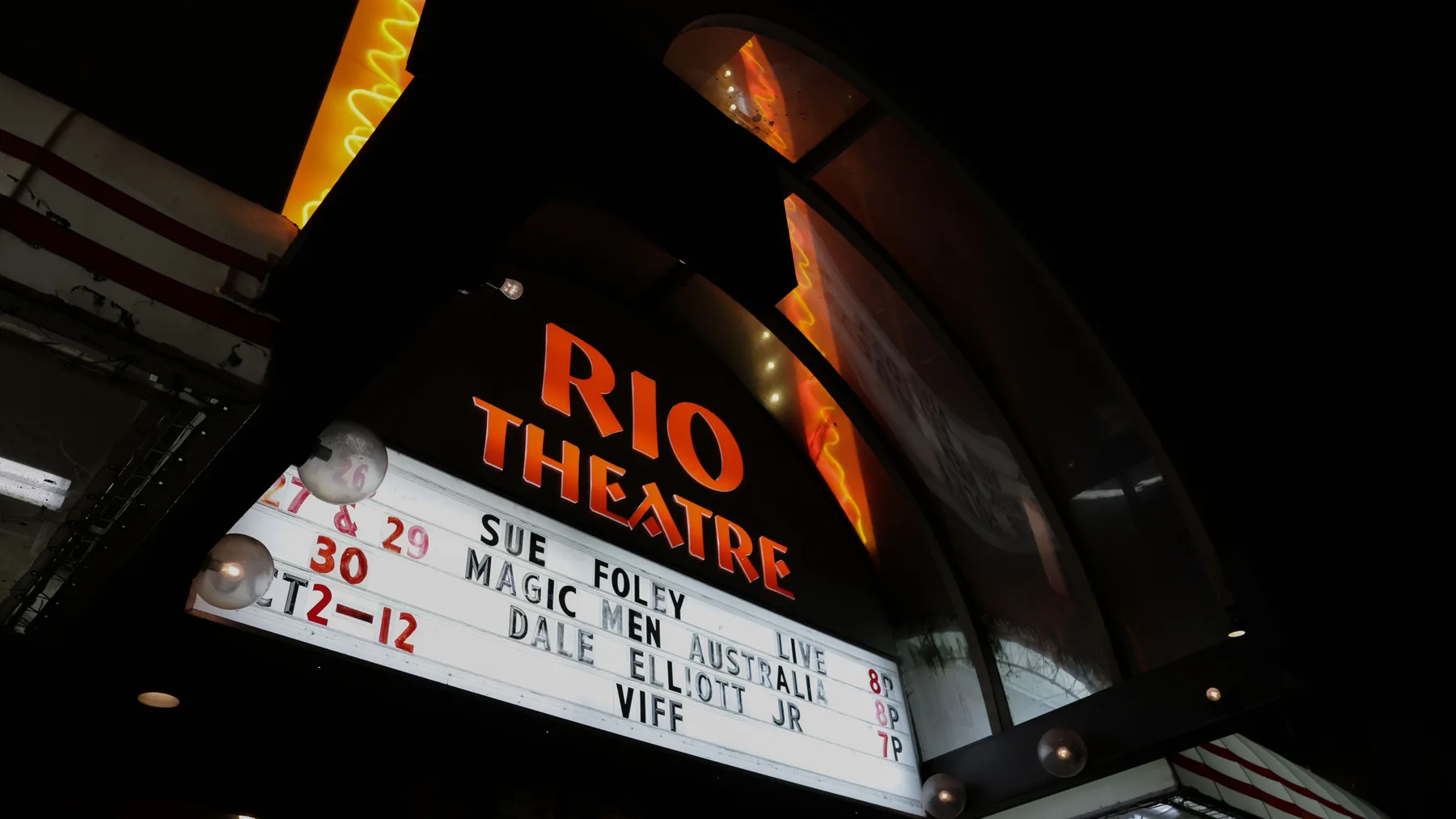 A photo of the Rio Theatre's programming sign at night.