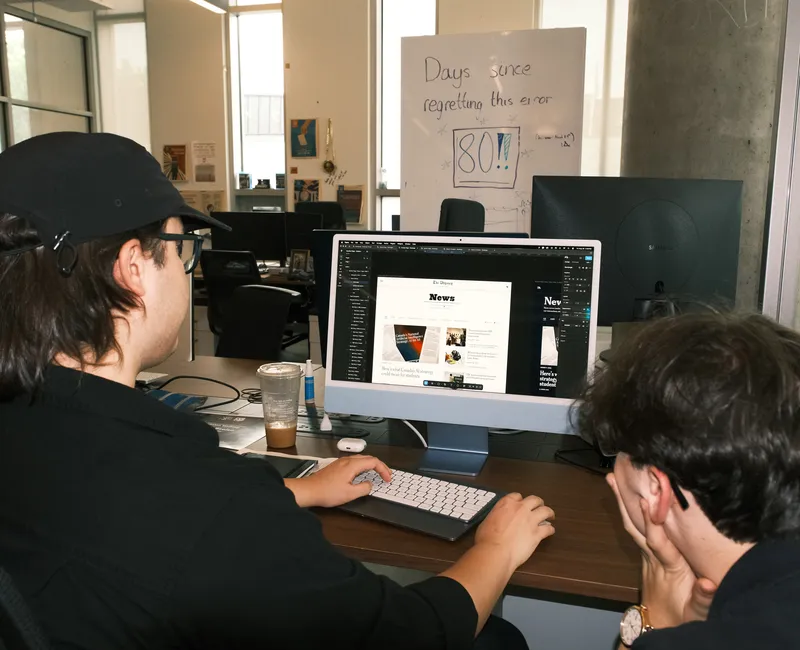 Desktop monitor displaying illustration software showing The Ubyssey's icon being redesigned.