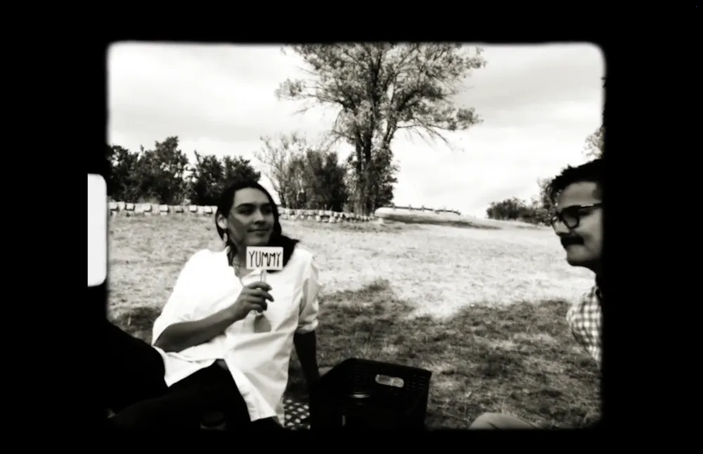 Two Two-Spirit people on a lawn, in black-and-white