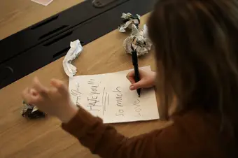A photo of someone writing a letter that reads "HATE YOU!!! so much."