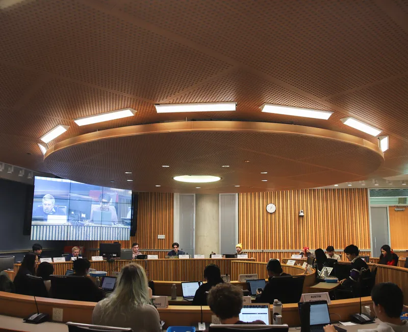 Wide eye view of Michael Kingsmill Forum, where AMS Councillors are sitting with their backs to the camera. VP Finance Gagan Parmar, President Riley Huntley, VP Admin Dylan Evans and VP Student Life Kevin Heieis are the only executives present.