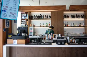 A photo of The Gallery's bar inside the Nest with a person in a green jersey standing behind the counter.