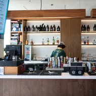 A photo of The Gallery's bar inside the Nest with a person in a green jersey standing behind the counter.