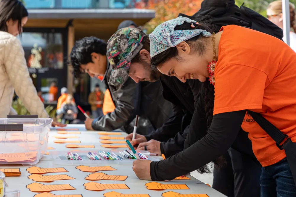 Throughout the event, volunteers encouraged people to write what reconciliation means to them and how they work towards it on orange shirt printouts.