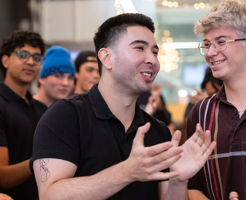 A photo of a man, who smiles and claps.