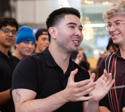 A photo of a man, who smiles and claps.