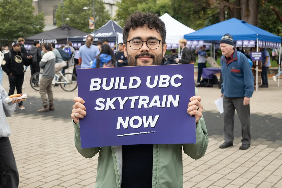 A student holds a placard facing the camera.