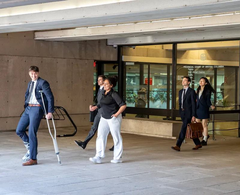 Several people in formal clothing leaving a courthouse.