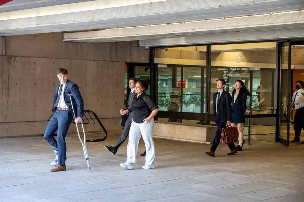 Several people in formal clothing leaving a courthouse.