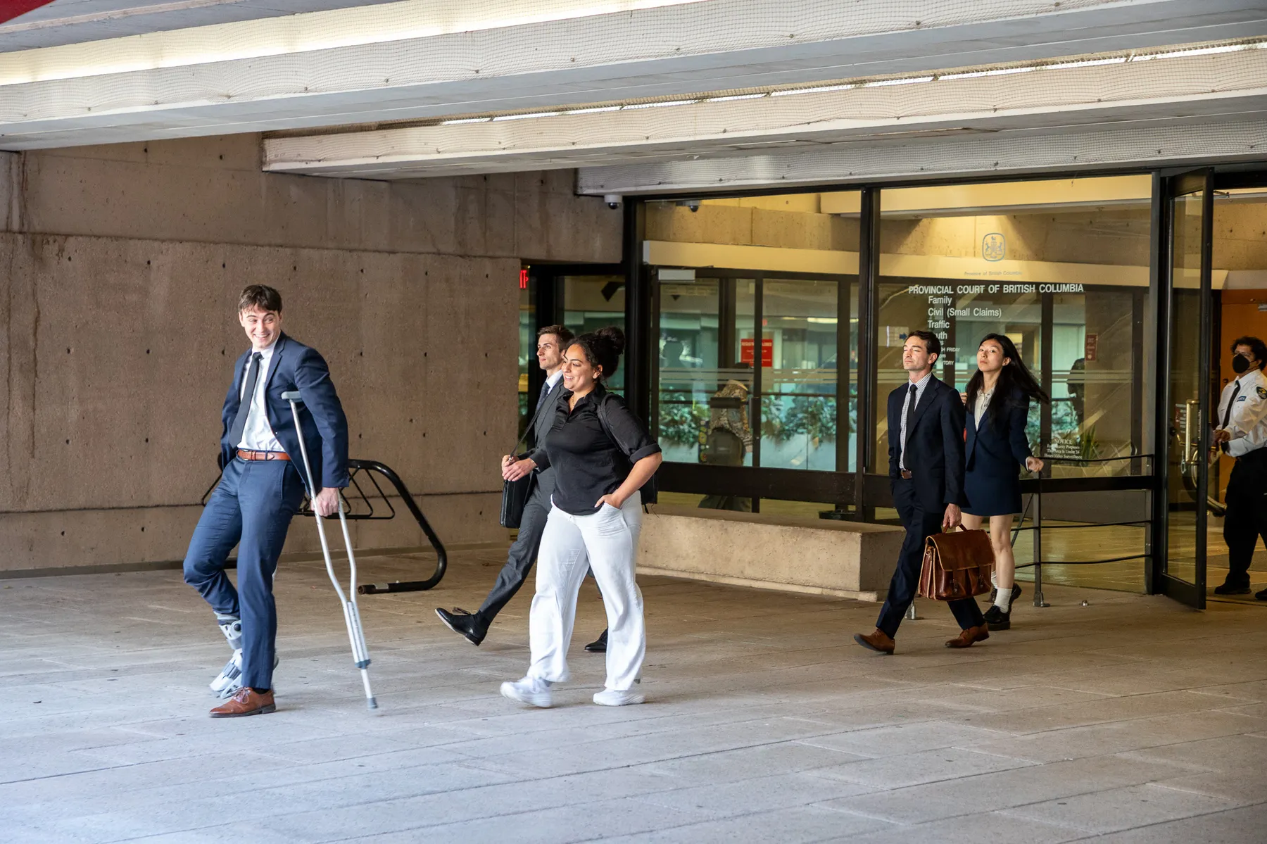 Several people in formal clothing leaving a courthouse.
