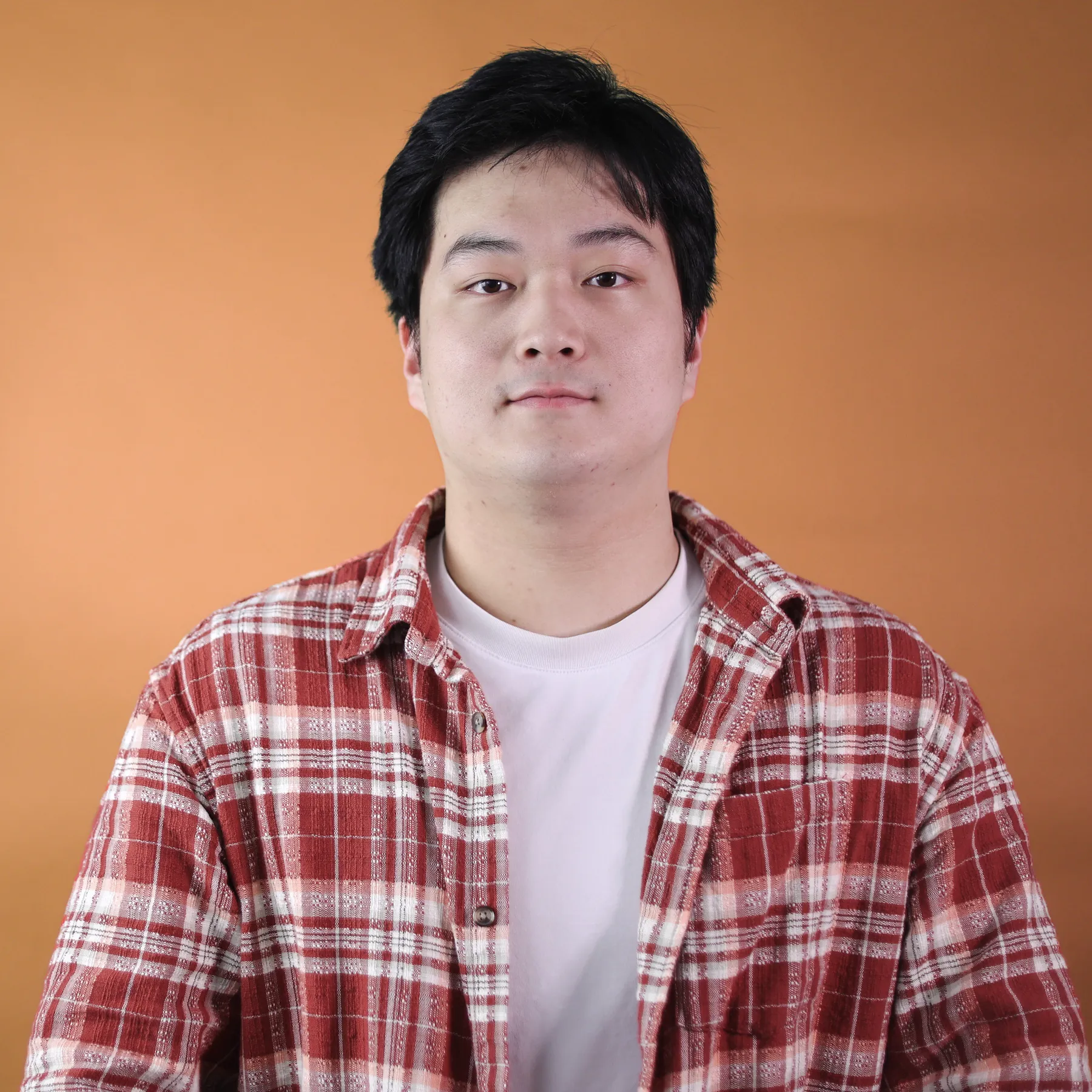A person in front of an orange background.