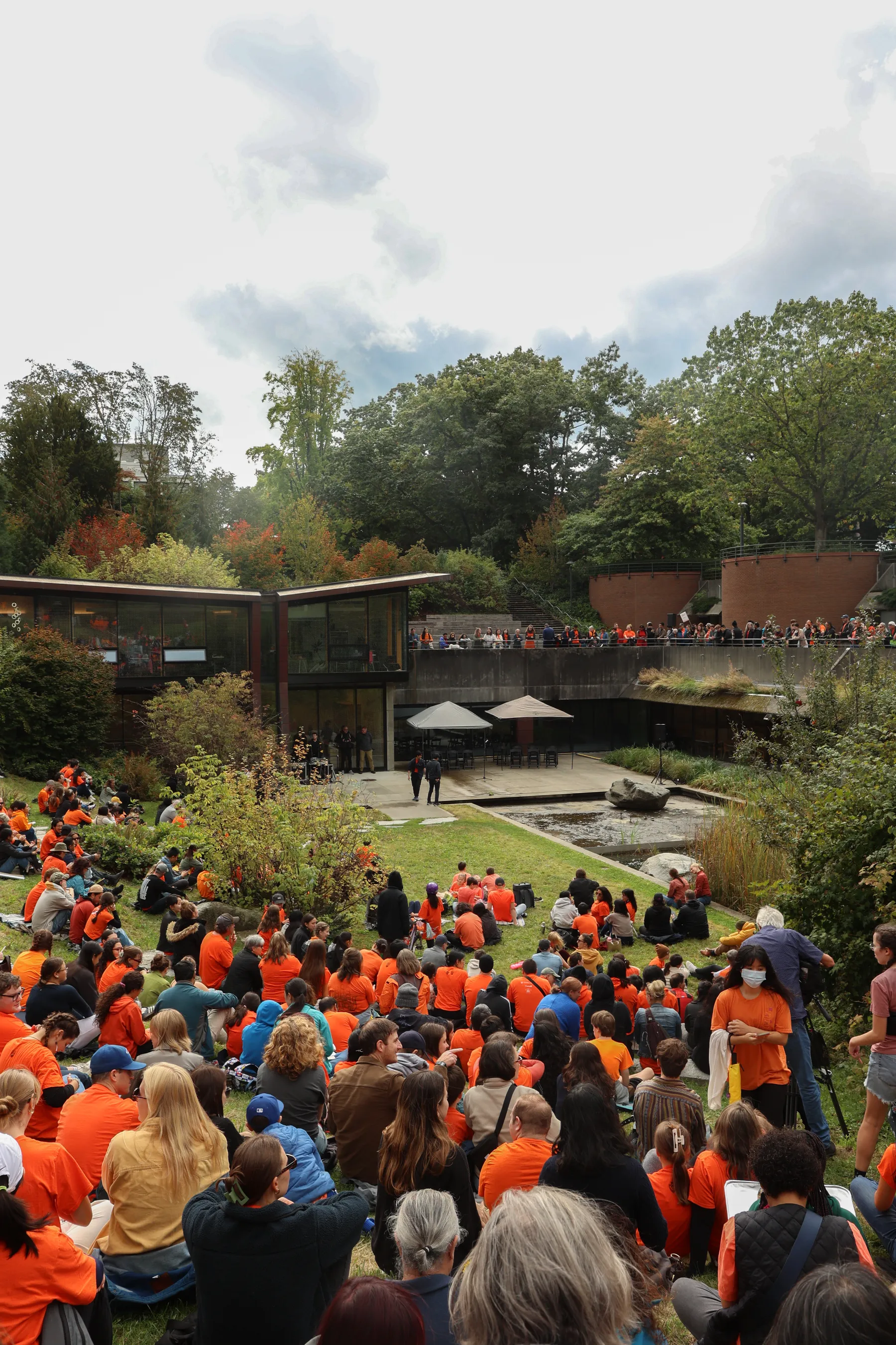 Two children add white handprints to the Engineering Cairn, painted orange.