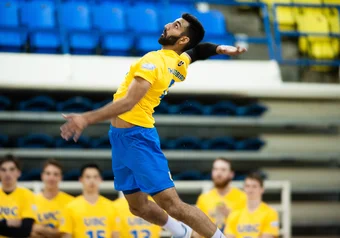 Volleyball player Irvan Brar delivers a serve against TRU.