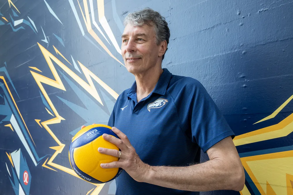 Reimer holds a volleyball near the Thunderbird mural outside War Memorial.