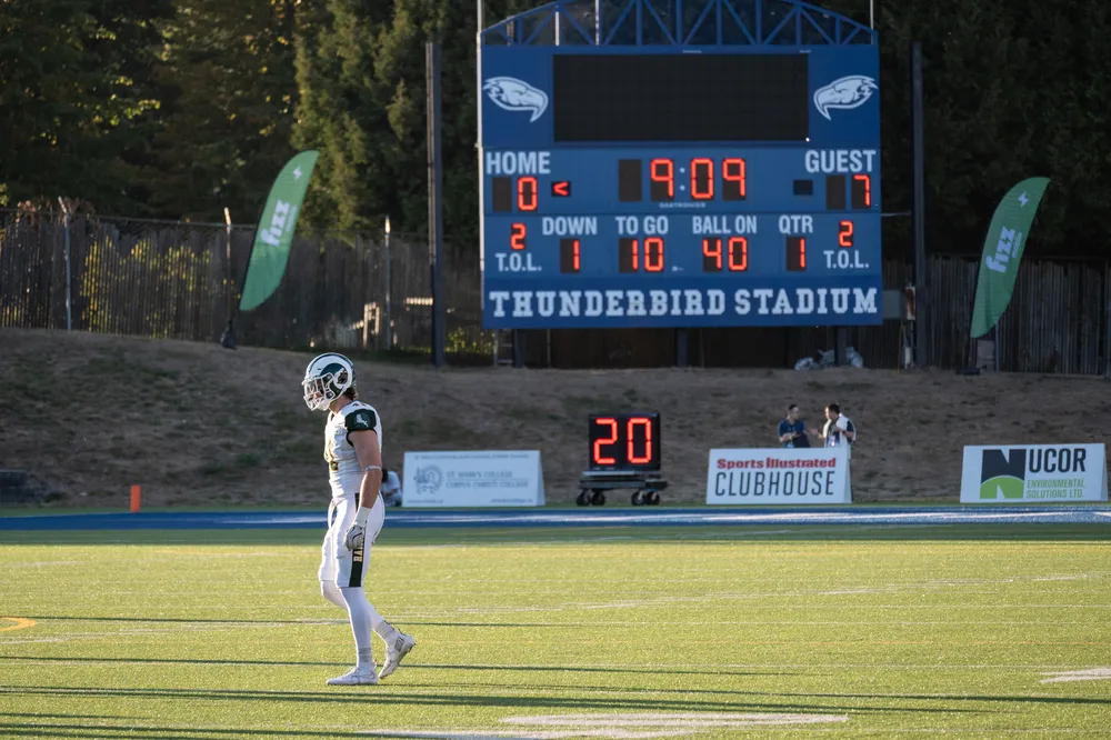A Rams player walks past the scoreboard as the team holds a 7-0 lead over the Thunderbirds early in the game.