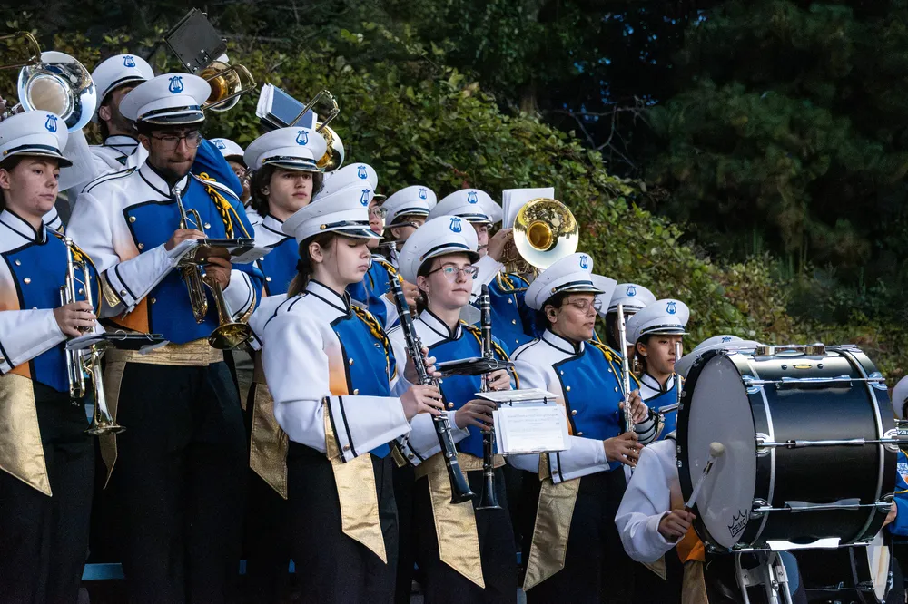 The Thunderbird Marching Band sits in the stands and performs throughout the game.