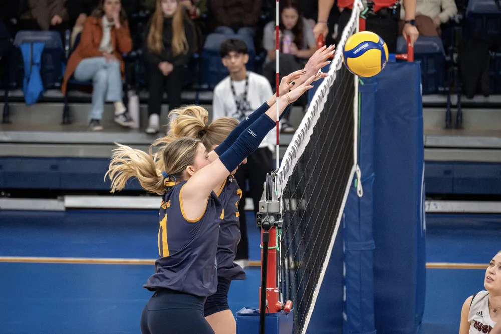 Ungemach and a teammate go up for the block at the net.