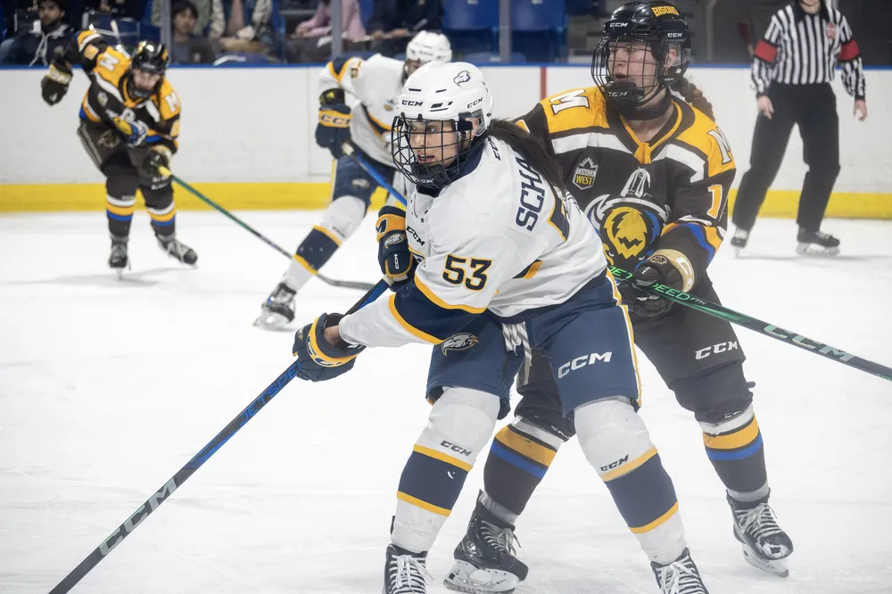 UBC's forward Vanessa Schaefer (#53) skates in close contest with a Bison.
