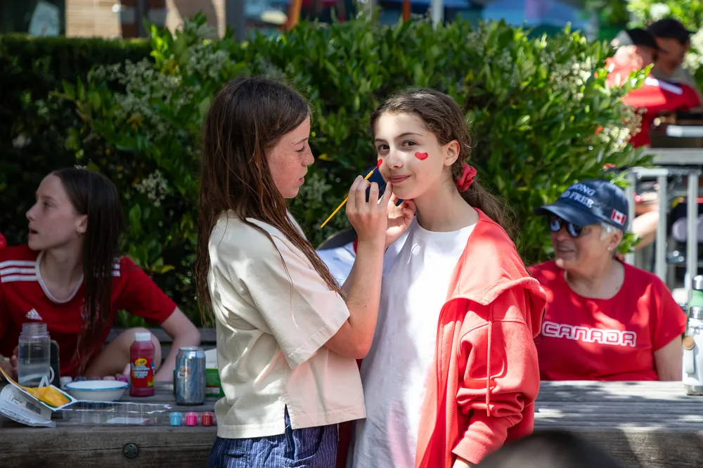 A girl gets her face painted to celebrate Canada's world cup match.