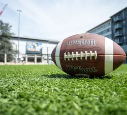 A football lying on the grass in front of War Memorial Gymnasium.