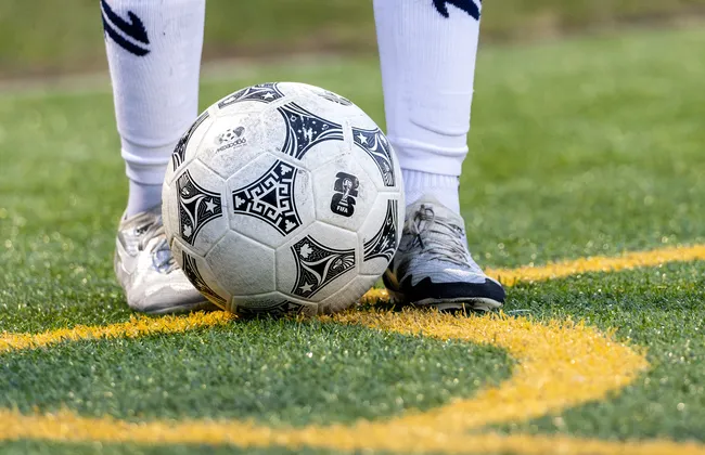 A close up of a soccer ball on a grass field.