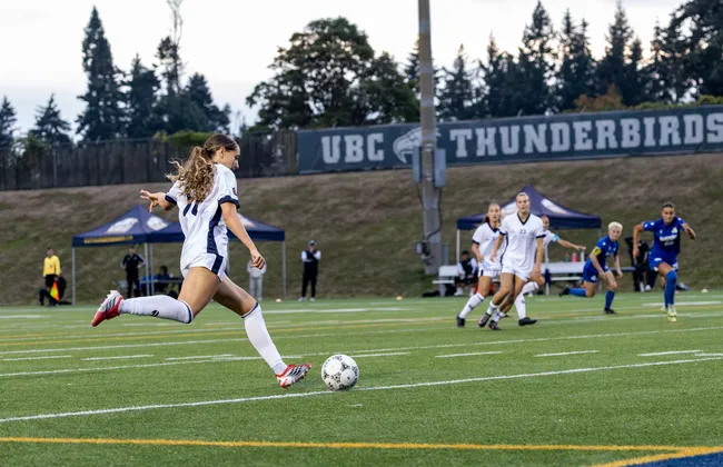 UBC player kicks the ball on the field