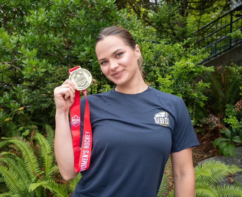Markova holding a gold medal from the Canada West championship.