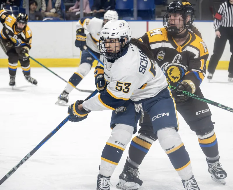 A UBC player in white gets positioning in front of a Bisons player in brown.
