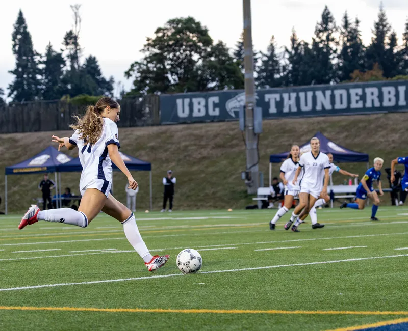 UBC player kicks the ball on the field