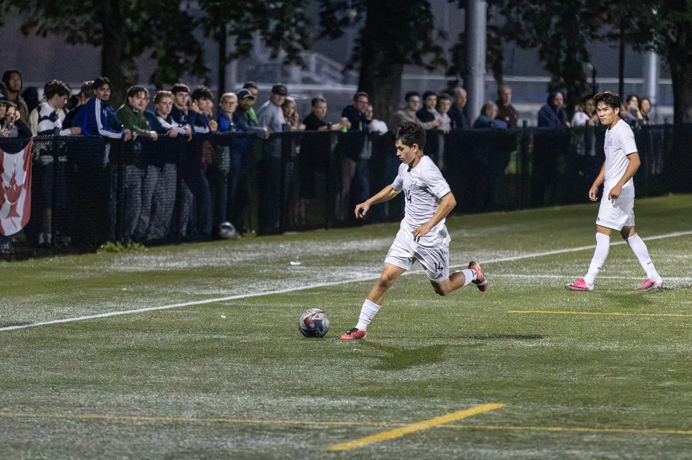 A UBC player dribbles the ball up the field.