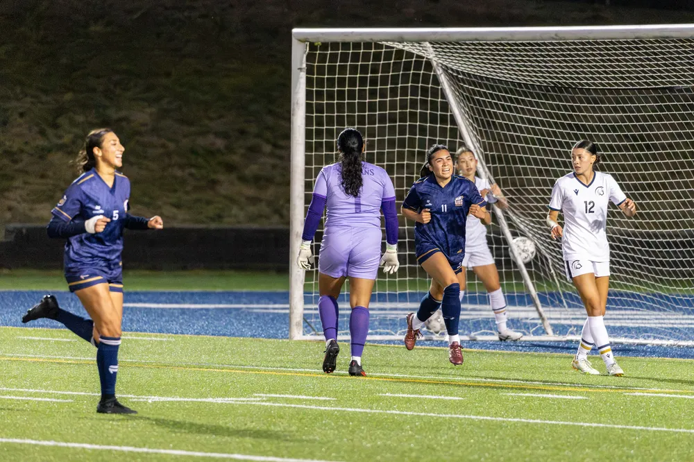 Abiera runs in front of the net, celebrating, with the ball visible in the back of the net.