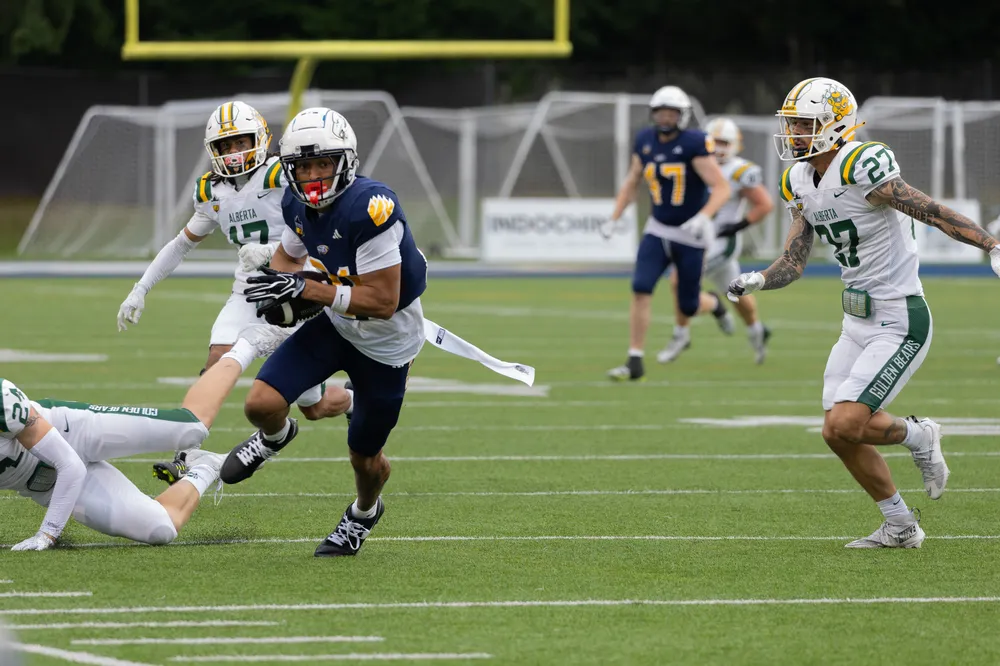 Montour turns up field after catching the ball behind two Alberta defenders.