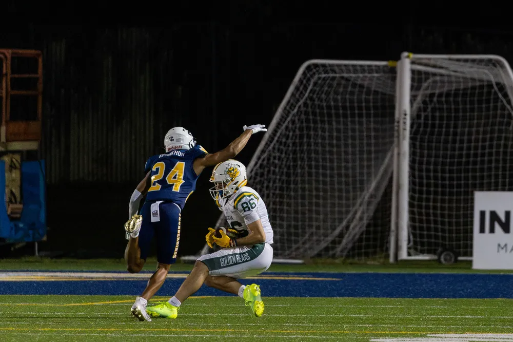 A UBC defender crashes down on an Alberta receiver.