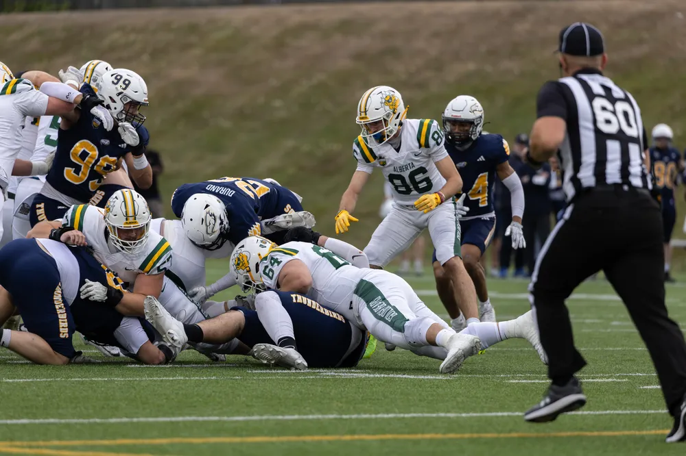 A pile of bodies forms while Alberta runs the ball.