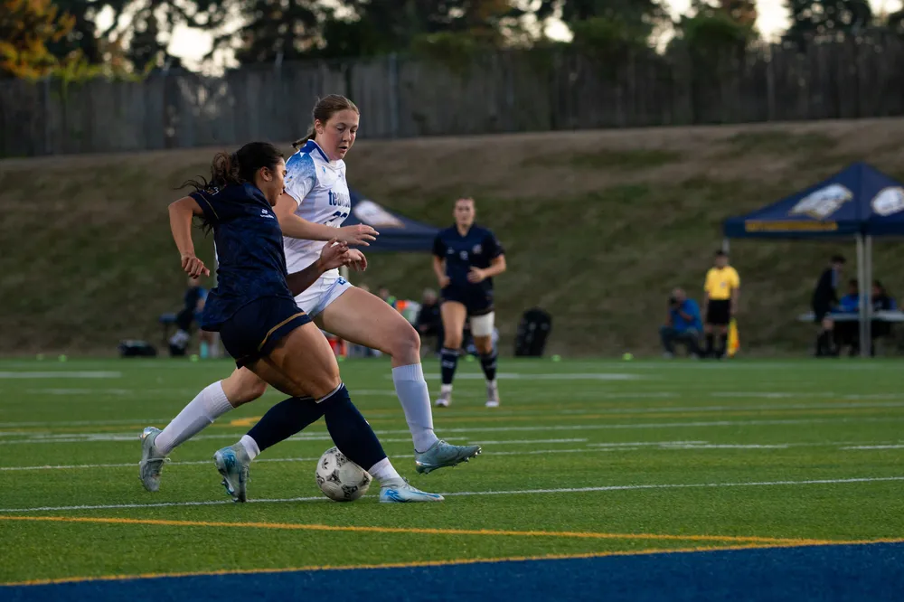 A UBC player attempts to get around a UVic player.