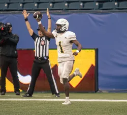 A UBC player holds the ball up in celebration.