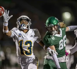 A T-Bird reaches out for a ball and barely misses it, with a Saskatchewan receiver nearby