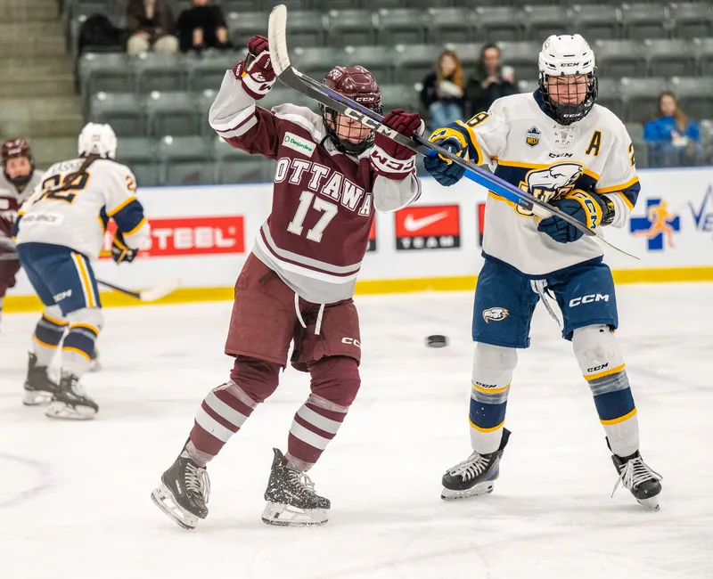 A UBC player in a white jersey fights for positioning with a Gee-Gee in burgundy.