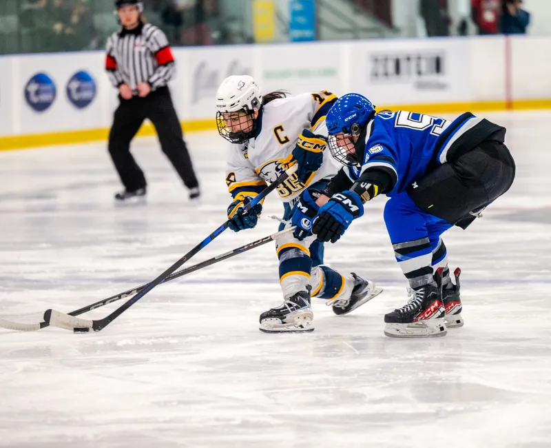 Wong, in a white jersey, gets a shot off with a Montreal defender in her face, in a blue jersey.