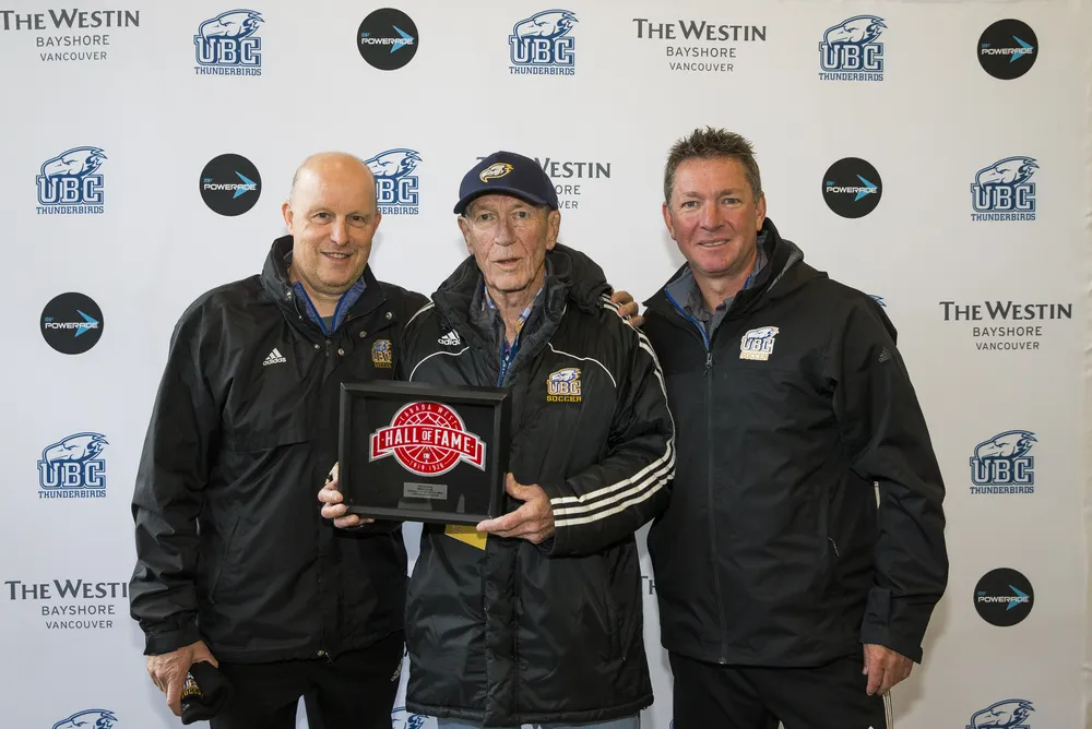 Dick and Mike Mosher stand beside long-time assistant coach David Partridge at Dick's Canada West Hall of Fame induction.