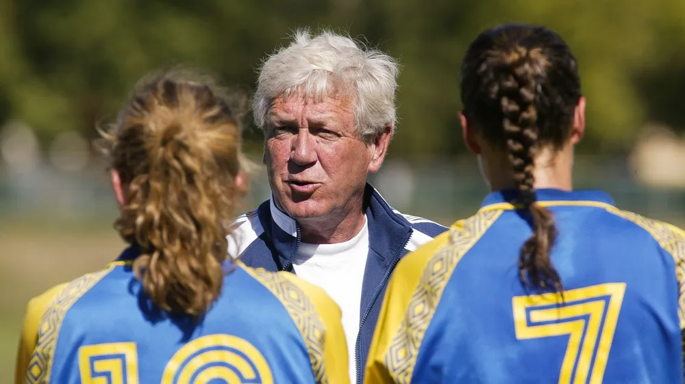 Dick Mosher talks to two of his players while coaching the women's team.