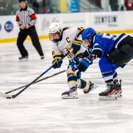 Wong, in a white jersey, gets a shot off with a Montreal defender in her face, in a blue jersey.