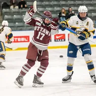 A UBC player in a white jersey fights for positioning with a Gee-Gee in burgundy.