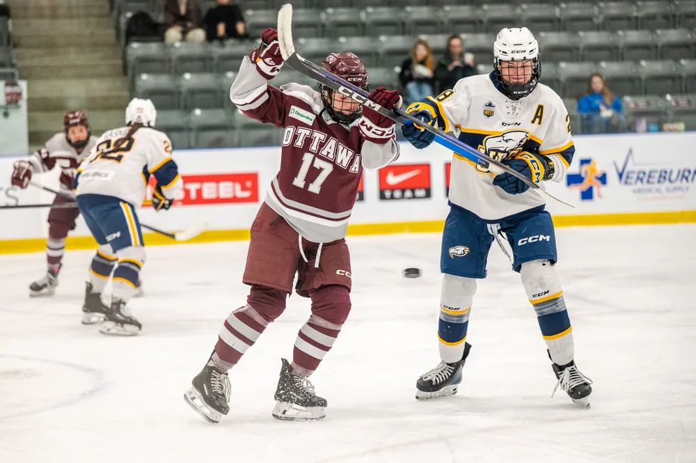 A UBC player in a white jersey fights for positioning with a Gee-Gee in burgundy.